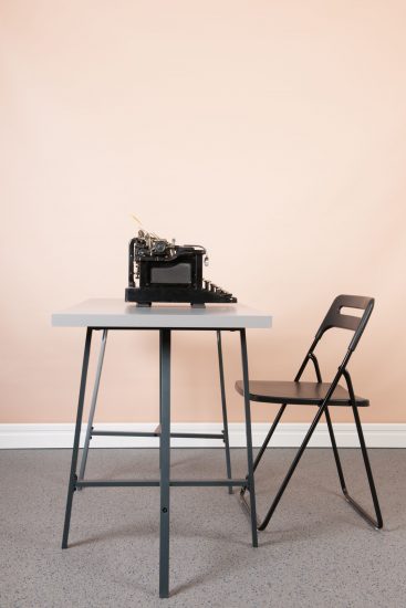 Empty desk at the office with old black typewriter